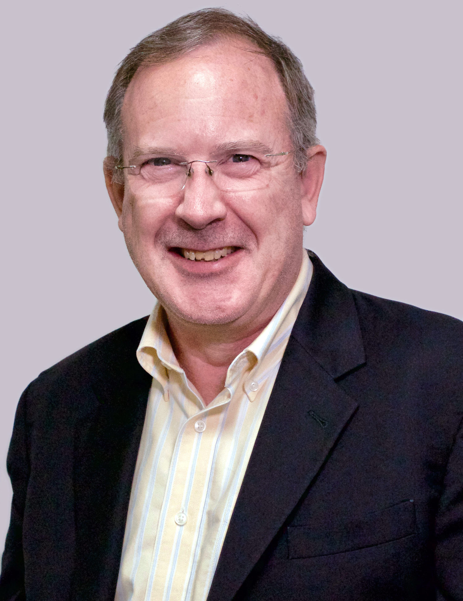 Neil Desnoyers is wearing a black business suit jacket and white collared shirt.